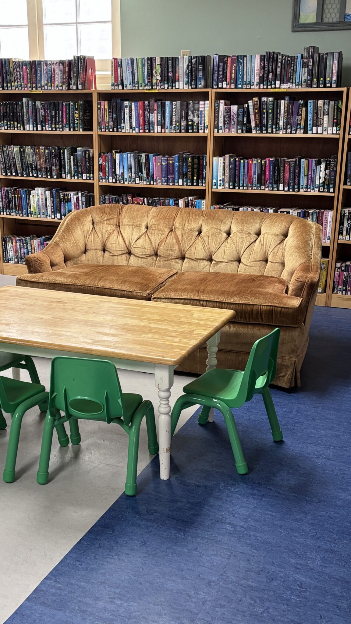Couch and table serves as a lounge space in the young adult area of the library.